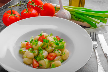 Vegetarian gnocchi with spring onions and tomatoes