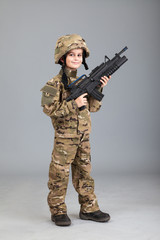 Young boy dressed like a soldier with rifle