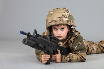 Young boy dressed like a soldier with rifle