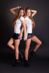 Two beautiful girls twins, isolated on black
