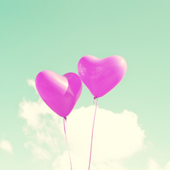 Fototapeta na wymiar Two purple heart-shaped balloons