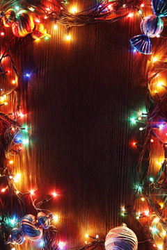 Christmas garlands of lamps on a wooden background.