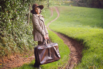 Smiling woman with vintage suitcase