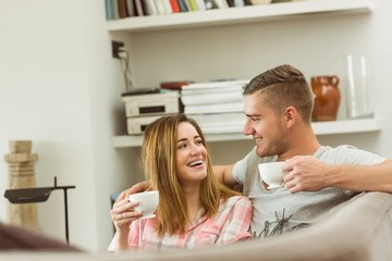 Cute couple relaxing on couch with coffee