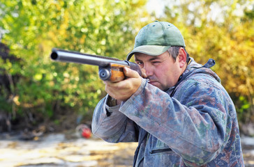 Hunter taking aim at the target. Hunter with a gun.