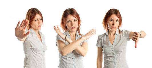 Obraz premium Young girl doing a bad signal over white background