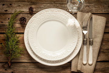 Vintage christmas table - empty white plate from above on wood