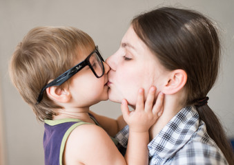 Young beautiful woman kissing her son