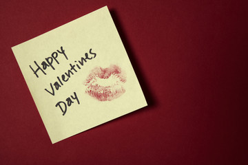 Fototapeta na wymiar Lipstick kiss on adhesive note for Valentine's day