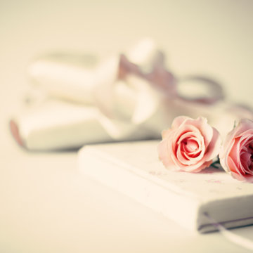 Vintage ballet shoes and roses over notebook