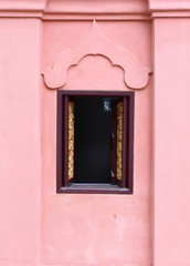 Thai temple window and orange concrete wall.