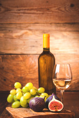 Obraz premium Barrel of white wine with bottle, glass and figs on a rustic tab