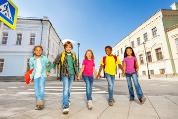 Obraz premium International schoolchildren walk and hold hands