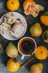 Tea, cinnamon sticks, muffins, pears, star anise and persimmons