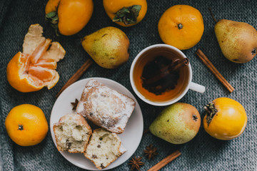 Tea, cinnamon sticks, muffins, pears, star anise and persimmons