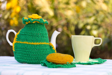 Knitted doily on the teapot on  natural background.