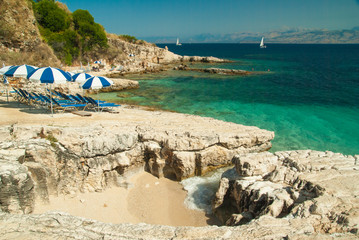 Sunbeds and umbrellas on the beach in Corfu Island, Greece