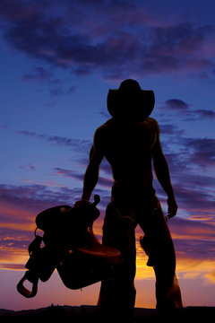 silhouette cowboy no shirt hold saddle look down