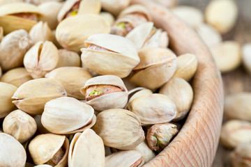 full bowl of pistachio on wooden surface
