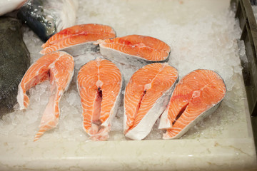 fresh salmon steaks on wooden pad
