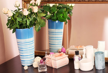 Beautiful vase with roses near mirror
