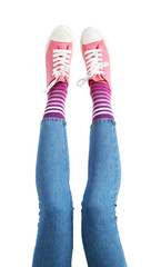 Female legs in colorful socks and sneakers isolated on white