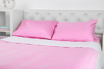 Bed in pink bed linen in room