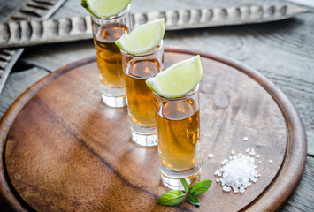 Glasses of tequila on the wooden board