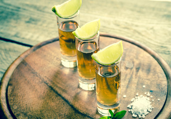 Glasses of tequila on the wooden board