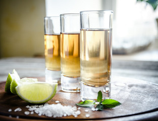 Glasses of tequila on the wooden board