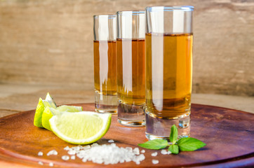 Glasses of tequila on the wooden board