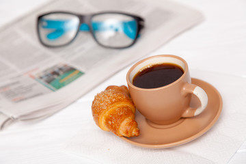 Coffee with croissant on a worktable