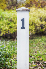Wooden post with number one in green grass