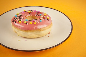 Colorful fresh doughnut on yellow background