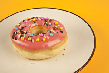 Colorful fresh doughnut on yellow background