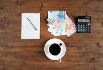 cup of coffee, calculator,  notepad and euro money