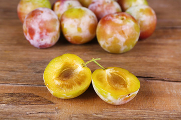 Ripe plums on wooden table close-up