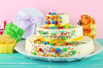 Beautiful tasty birthday cake and gifts on color background