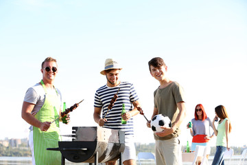 Young friends having barbecue party, outdoors