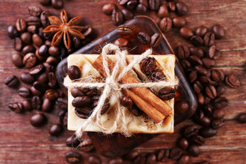 Organic soap with coffee beans and spices on wooden background