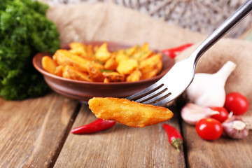 Homemade fried potato on plate on wooden background