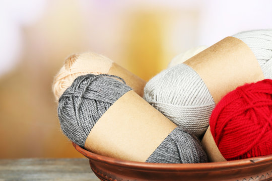 Knitting yarn on wooden table, on light background