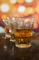 shots of rum whiskey over defocused lights background