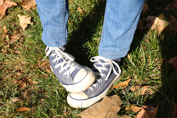 Feet in sneakers on grass background