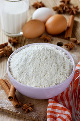 Flour in bowl with eggs, milk, cinnamon sticks and anise star