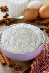 Fototapeta na wymiar Flour in bowl with eggs, milk, cinnamon sticks and anise star