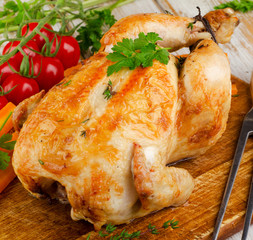 Roasted chicken with vegetables on   wooden board.