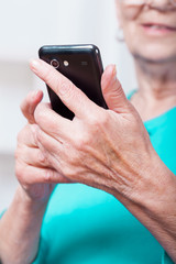 Senior woman sending text message