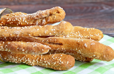 Grissini with prosciutto crudo and vegetables on wooden table