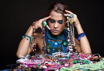 Brunette woman and heap of bijouterie
